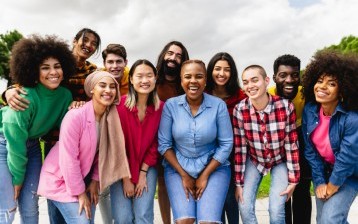 Young multiracial friends having fun together hanging out in the city - Friendship and diversity concept